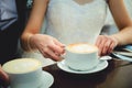 Bride and groom on their wedding day, drink coffee in a cafe Royalty Free Stock Photo