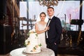 bride and groom with traditional white wedding cake decorated with flowers Royalty Free Stock Photo