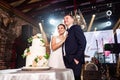 bride and groom with traditional white wedding cake decorated with flowers Royalty Free Stock Photo