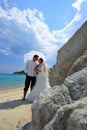 Bride and groom on tropical beach under umbrella Royalty Free Stock Photo