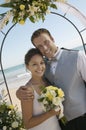 Bride and Groom under archway on beach Royalty Free Stock Photo