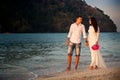 Bride and groom walk at beach at dawn Royalty Free Stock Photo
