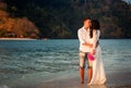 bride and groom walk at beach at dawn Royalty Free Stock Photo