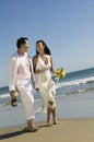 Bride and Groom walking on beach Royalty Free Stock Photo