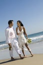 Bride and Groom walking on beach Royalty Free Stock Photo