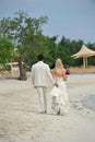 Bride and groom walking on beach