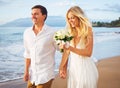 Bride and Groom Walking on Beautiful Tropical Beach at Sunset, R Royalty Free Stock Photo