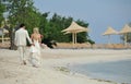 Bride and groom walking on caribbean beach Royalty Free Stock Photo