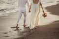 Bride groom walking on choppy Beach, bride has flowers in her hand Royalty Free Stock Photo