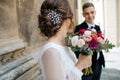 Bride and groom walking in a sunny city at large buildings Royalty Free Stock Photo