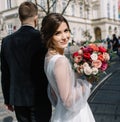 Bride and groom walking in a sunny city at large buildings Royalty Free Stock Photo