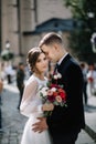 Bride and groom walking in a sunny city at large buildings Royalty Free Stock Photo