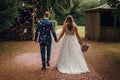 Bride and groom walking in the park with confetti on their wedding day. Bride and groom holding hand united in love and commitment Royalty Free Stock Photo
