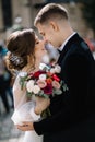 Bride and groom walking in a sunny city at large buildings Royalty Free Stock Photo