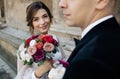 Bride and groom walking in a sunny city at large buildings Royalty Free Stock Photo