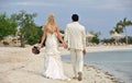 Bride and groom walking together on beach Royalty Free Stock Photo