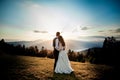Bride and groom watch the sunset standing on the hill Royalty Free Stock Photo