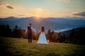 Bride and groom watch the sunset standing on the hill Royalty Free Stock Photo