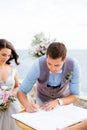 the bride and the groom at the wedding ceremony, the groom signs Royalty Free Stock Photo