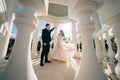 bride and groom in wedding clothes dance in gazebos or rotunda in the park.