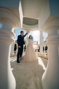 bride and groom in wedding clothes dance in gazebos or rotunda in the park.