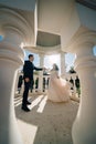 bride and groom in wedding clothes dance in gazebos or rotunda in the park.