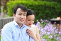 Bride and groom in wedding dress with elegant hairstyle, with white wedding dress Sitting on the bench next to the fence Royalty Free Stock Photo