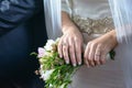 Bride and groom at the wedding with focus on bride`s manicured hands with engagement ring and gold wedding band