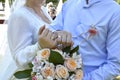 The bride and groom with wedding rings on their fingers hold a bouquet Royalty Free Stock Photo