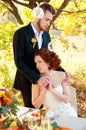 Bride and groom at the wedding table. Autumn outdoor setting. Royalty Free Stock Photo