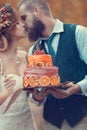 The bride and groom on a wedding walk kiss with a beautiful wedding cake Royalty Free Stock Photo