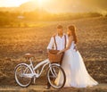 Bride and groom with a white wedding bike