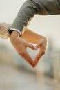 Bride and groom& x27;s hands forming heart shape in the rain on blur background Royalty Free Stock Photo