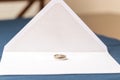 A bride and grooms wedding bands photographed in the center of wedding invitations