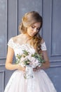 A bride with hairstyle and make up in gorgeous pink wedding dress and a vail with a bouquet of peonies. Royalty Free Stock Photo