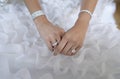 Bride hand with beautiful diamond ring on white wedding dress Royalty Free Stock Photo