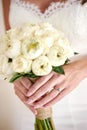 The bride hand with wedding ring, holding the white cream lotus and roses flower bouquet - closed up Royalty Free Stock Photo