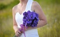 Bride hands holding purple flowers