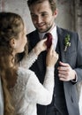 Bride Helping Groom Dressing Up for Wedding Ceremony