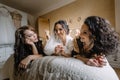 Beautiful bride and bridesmaids posing near window, wedding prepar Royalty Free Stock Photo