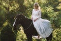 Bride with her horse outdoor. Woman in wedding dress.