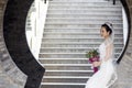 Bride hold bridal bouquet with white wedding dress near a brick arch Royalty Free Stock Photo