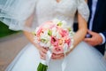 Bride hold groom by the hand and wedding bouquet. Focus on wedding flower bouquet. Crop by chest and legs. Bride in wedding dress Royalty Free Stock Photo