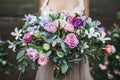 Bride holding beautiful colorful wedding bouquet of roses, peonies and tulips Royalty Free Stock Photo