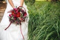 bride holding a bouquet of red flowers of zinnias Royalty Free Stock Photo