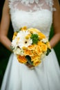 The bride holding a bouquet with yellow flowers