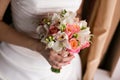 Bride holding bridal bouquet close up. pink and white roses, freesia, brunia decorated in composition Royalty Free Stock Photo