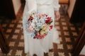 Bride holding a delicate bouquet of white and pink flowers, wearing a traditional white wedding gown Royalty Free Stock Photo