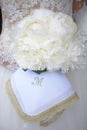 Bride holding an exquisite white peonies wedding bouquet and an embroidered linnen napkin monogrammed with letter M Royalty Free Stock Photo