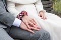 Bride holding groom hand with wedding rings sitting on bench Royalty Free Stock Photo
